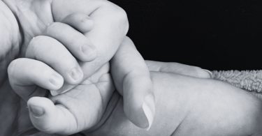 Mano de un bebé sujetando el dedo de su madre.