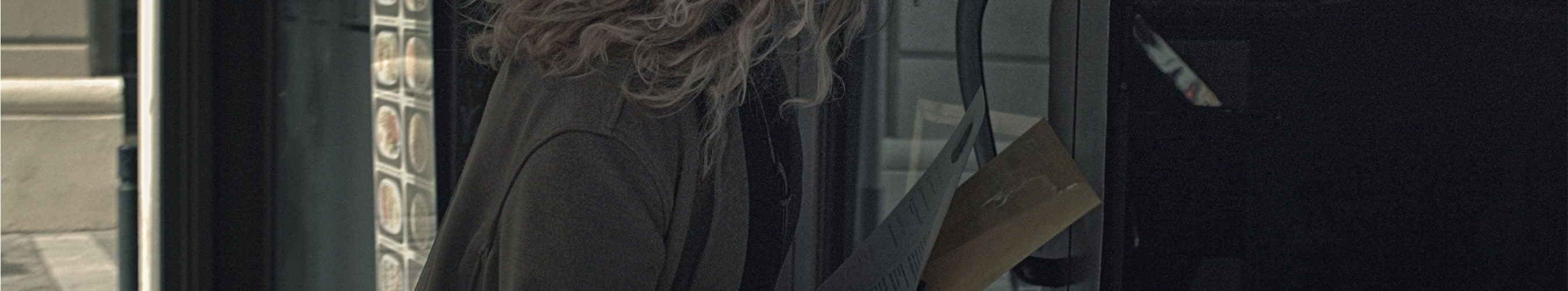 Mujer migrante cubana entregando su currículum en la puerta de un local en Barcelona, en busca de trabajo informal.