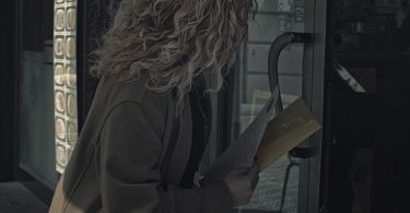 Mujer migrante cubana entregando su currículum en la puerta de un local en Barcelona, en busca de trabajo informal.