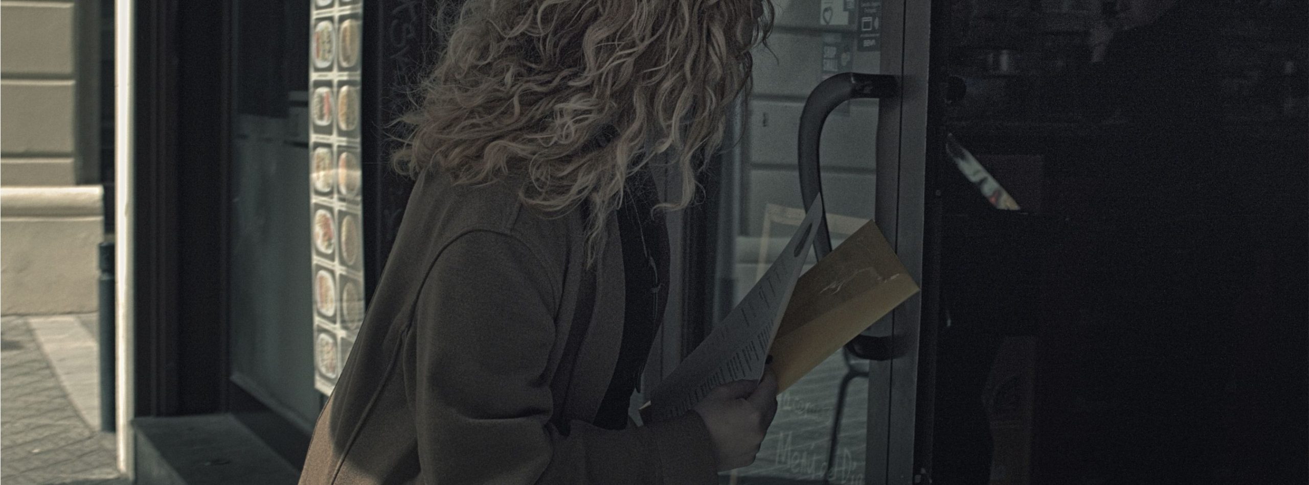 Mujer migrante cubana entregando su currículum en la puerta de un local en Barcelona, en busca de trabajo informal.