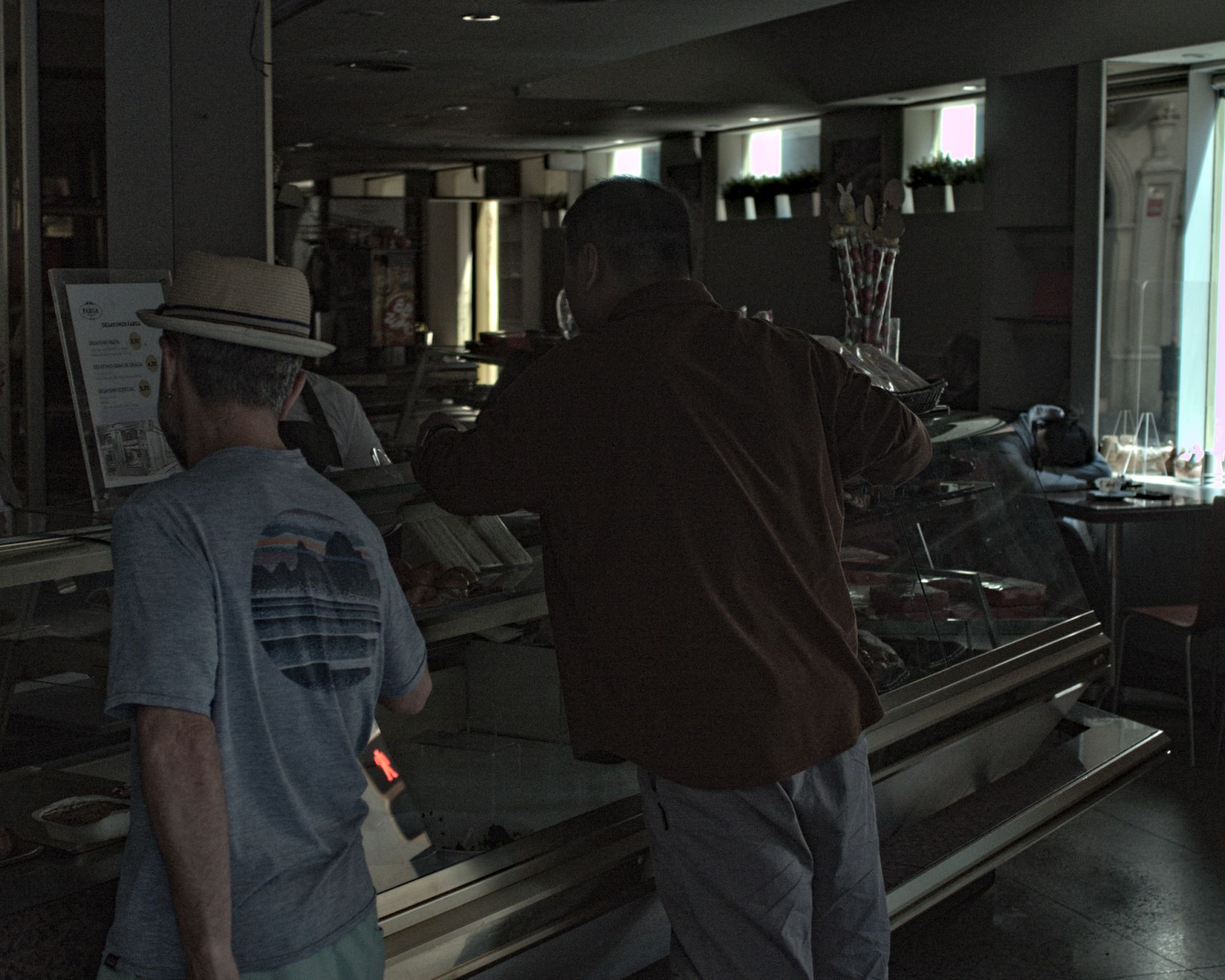 Interior oscuro de una panadería atendiendo sin luz.