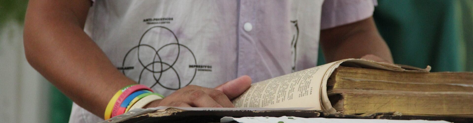 Grupo de hombres rodean a una persona en el centro, colocando sus manos sobre su espalda y hombro en gesto de apoyo y consuelo durante un acto religioso